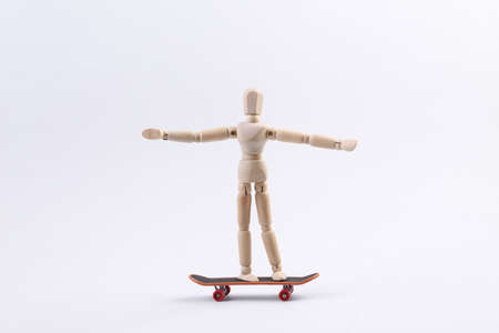 Wooden puppet is riding a skateboard.の写真素材