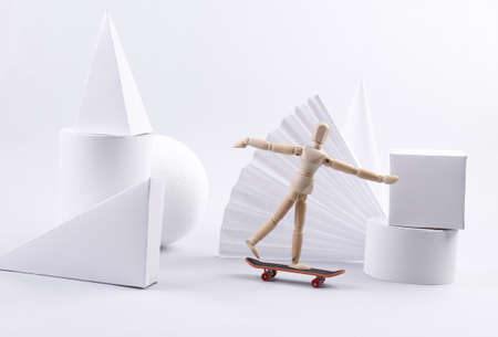 Wooden puppet is riding a skateboard. Geometric figures. concept artの写真素材