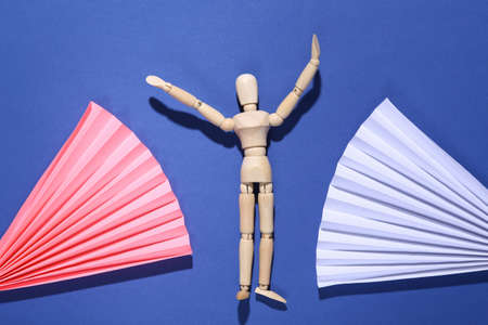 Wooden puppet on abstract background with fan. minimalism. concept art. creative layoutの写真素材