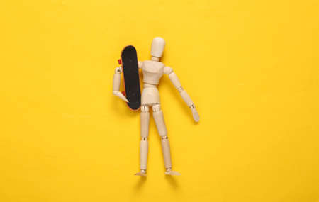 Puppet with skateboard on yellow backgroundの写真素材
