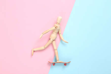 The puppet is riding a skateboard. blue pink pastel backgroundの写真素材