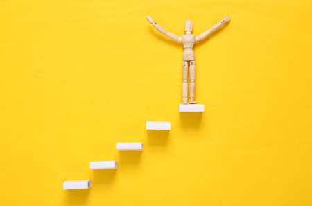career growth concept. Wooden stairs on a yellow background