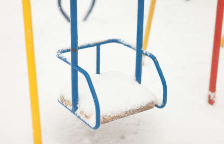 Swing in the snow. Playground in winterの写真素材