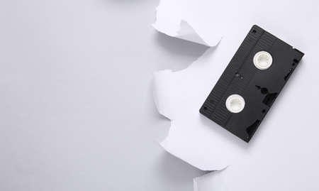 Retro video casette and white torn paper sheet on gray background. top view. copy spaceの写真素材