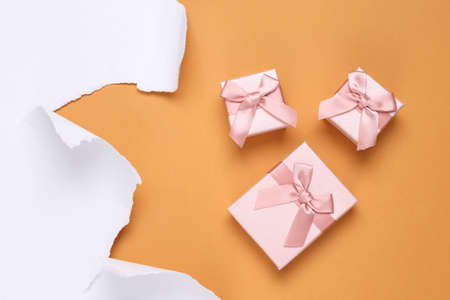 Gift boxes and white torn paper sheet on beige background. copyspace. top viewの写真素材