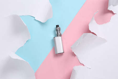 Vaping device on blue-pink background with torn paper. concept art. Pastel color trend. creative...