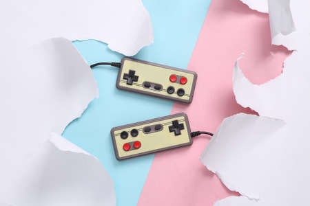 Retro gamepad on blue-pink background with torn paper. concept art. Pastel color trend. top view