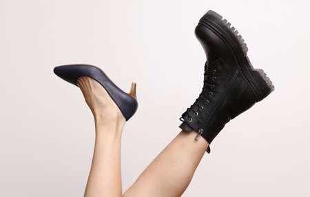Choice of shoes. Female bare feet in boot and high heel shoe on white background. fashion concept