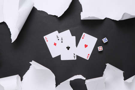 Four aces and dice on black background with white torn paper. concept art. minimalism. top view