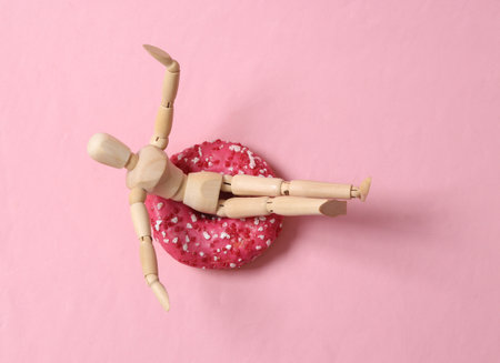 Wooden puppet with a donut. Beach vacation concept, summer fun