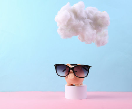 Piggy bank with sunglasses with cloud on pastel pink blue background. creative ideas. Summer rest. minimal concept. pastel color trendsの写真素材