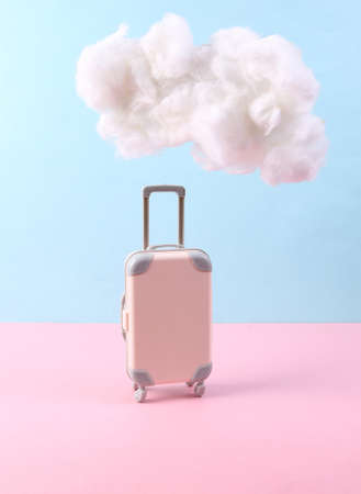 Travel luggage with fluffy cloud on pastel pink blue background. creative ideas. Minimal travel...