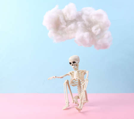 Skeleton with cloud on pastel pink blue background. creative ideas. minimal concept. pastel color trendsの写真素材