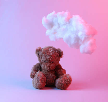 Teddy bear and floating fluffy cloud in blue pink neon gradient light. creative ideas. concept art....