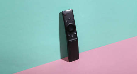 Tv remote on blue-pink background. minimalism. trendy shadow. creative layout.の写真素材