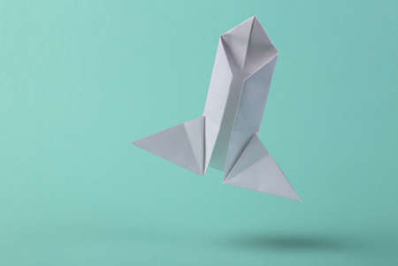 Taking off origami rocket on a blue background. startup. Space flights
