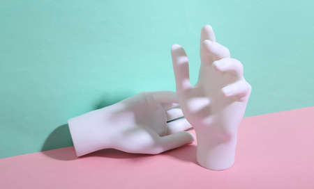 White mannequin hands on blue-pink background. minimalism. trendy shadow. creative layout.の写真素材