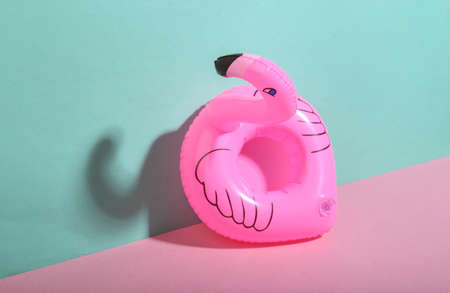 Inflatable flamingo on blue-pink background. minimalism. trendy shadow. creative layout.