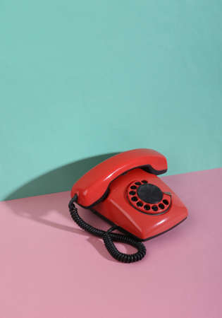 Creative retro 80s still life. Retro rotary phone on pink blue pastel background. minimalism. trendy shadow.の写真素材