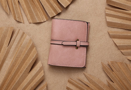 creative fashion layout. Leather purse and dry palm leaves on beige background. flat lay