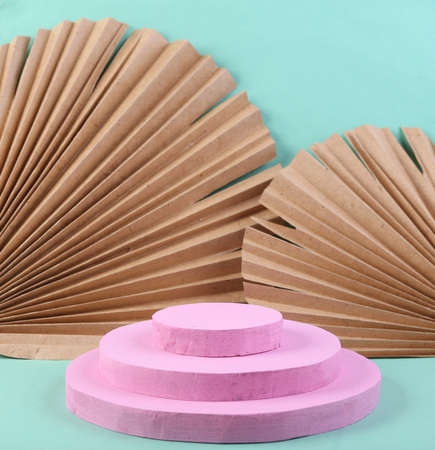 Pink podium on blue background with dry palm leaves. Platforms for product presentation, mock up background. Abstract composition in minimal design.の写真素材