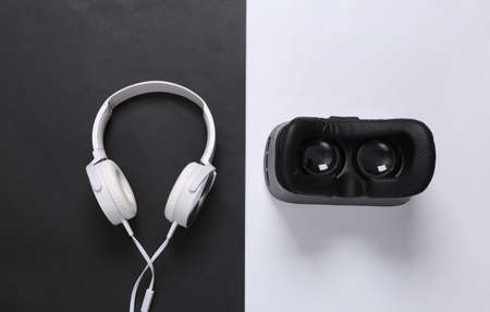 Modern gadgets. Headphones and vr helmet on white black background. top view