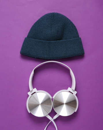 Beanie and stereo headphones on a purple background. Youth party, music conceptの写真素材