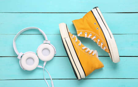Headphones and sneakers on blue wooden background. Youth, music concept. top view. flat layの写真素材