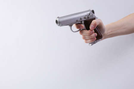 Hand holds video game gun on gray backgroundの写真素材
