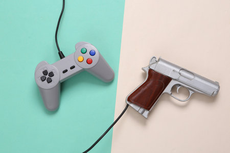 Gamepad and video game gun on mint green beige background. gaming concept. top view