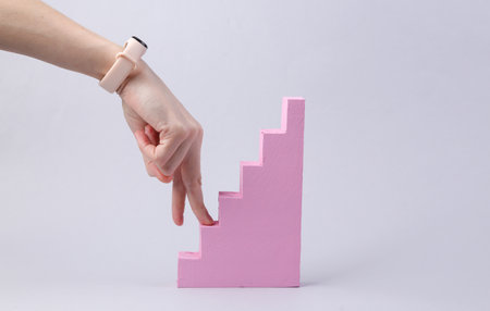 Fingers climb the stairs against gray background. career growth concept. minimalism