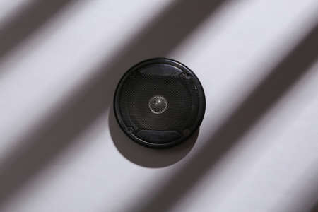minimalistic layout. Audio speaker with long striped trendy shadows on gray background. top viewの写真素材