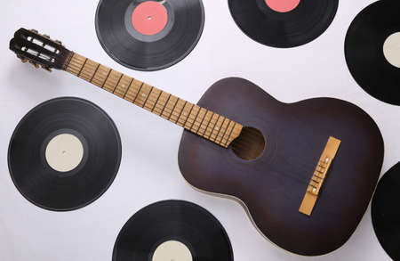 Acoustic guitar, vinyl records on white background. musical concept. top view. flat lay