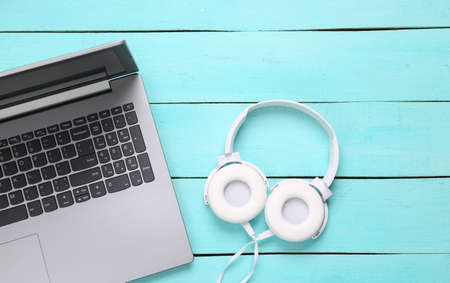 Laptop and Stereo headphones on blue wooden background. top view. flat layの写真素材