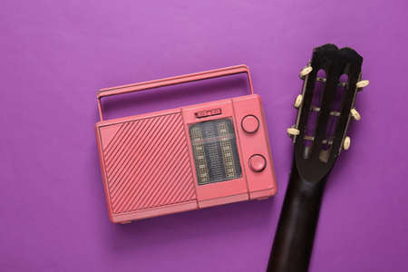 Acoustic guitar and radio receiver on a purple background. musical concept. top view. flat layの写真素材