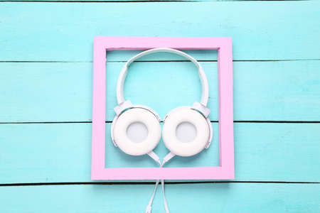 Stereo headphones with frame on blue wooden background. top view. minimalist compositionの写真素材