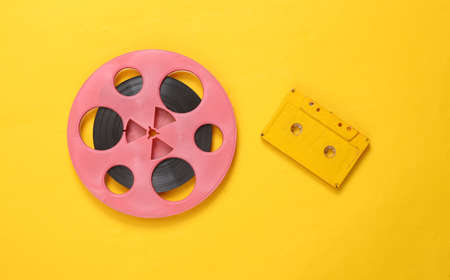 Pink retro audio reel and audio cassette on yellow background. Minimalism music concept. top viewの写真素材