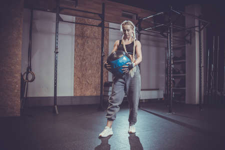 Young athletic woman with medicine ball in modern gymの写真素材
