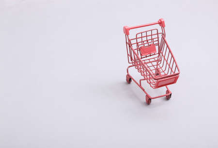 Mini pink supermarket trolley on gray background. shopping conceptの写真素材