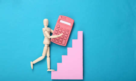 Puppet with calculator climbs up the stairs on blue background. career growth conceptの写真素材