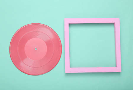 creative music layout. Pink vinyl record with empty frame on mint blue background. minimalism. flat...