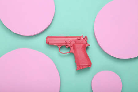 creative minimal layout. Pink gun with circles on mint blue background. minimalism. concept art....
