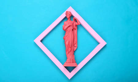creative layout. Pink Antique greek goddess statue in frame on blue background. minimalism. flat lay. top viewの写真素材