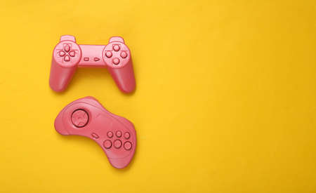 creative gaming layout. Retro gamepads on yellow background. minimalism. concept art. copyspace. flat lay. top view.の写真素材
