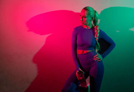 Fitness model posing in pink green neon gradient light. Sport, fitness, lifestyle concept