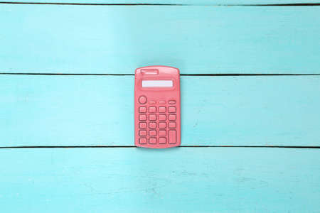 creative layout. Pink calculator on blue wooden background. minimalism. top view. flat lay