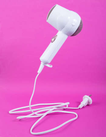 Levitating hair dryer on pink background. Minimalistic beauty and fashion still life. creative...