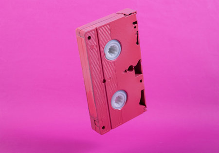 Levitating pink video cassette on pink background. Minimalistic still life. creative layout. concept artの写真素材
