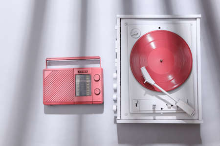 White vinyl record player and fm radio on gray background with trendy striped shadow. Minimalism music concept. creative layoutの写真素材