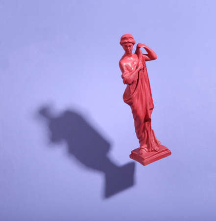Levitating pink antique goddess statue on purple background with shadow. 3D photo. Minimalistic still life. creative layout. concept artの写真素材